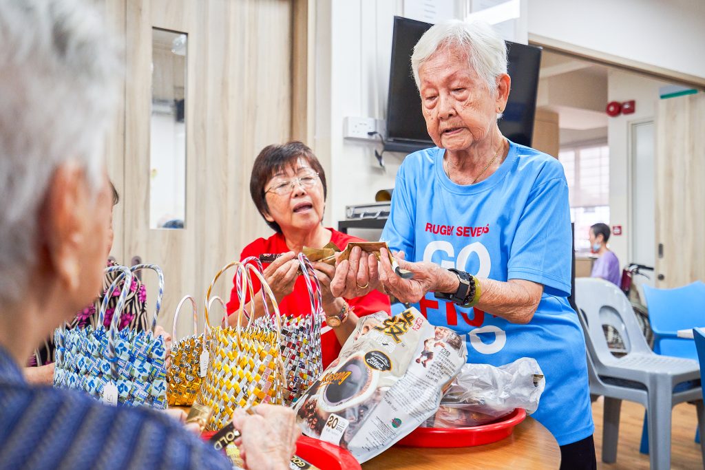 Mdm Wong teaching arts and crafts to other seniors in the Active Ageing Centre